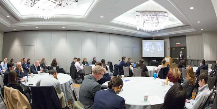 people at tables listening to a talk